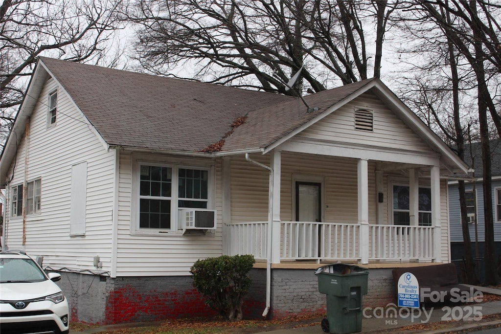 bungalow-style home featuring cooling unit and a porch