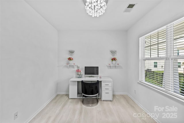 office with an inviting chandelier and light hardwood / wood-style floors