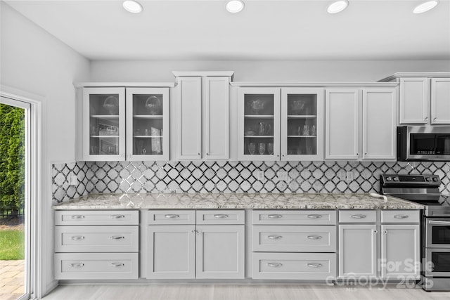 kitchen featuring white cabinetry, appliances with stainless steel finishes, and backsplash