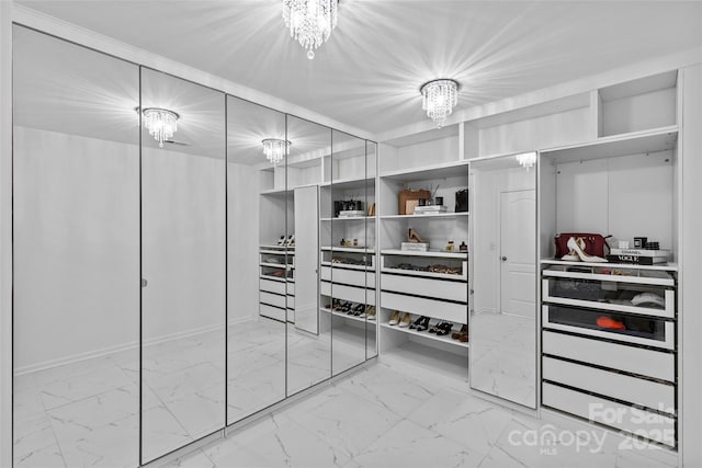 spacious closet featuring a notable chandelier