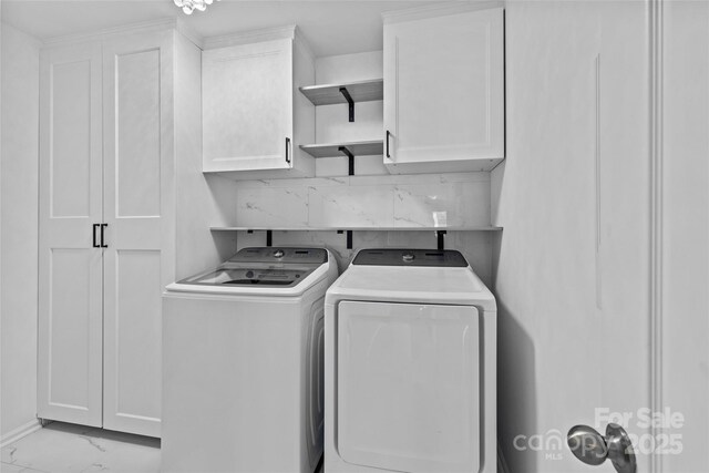 laundry area featuring washer and dryer and cabinets