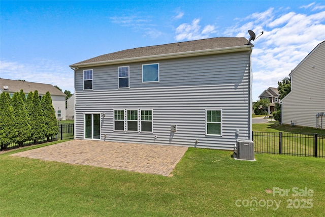 rear view of property with central AC unit, a yard, and a patio area