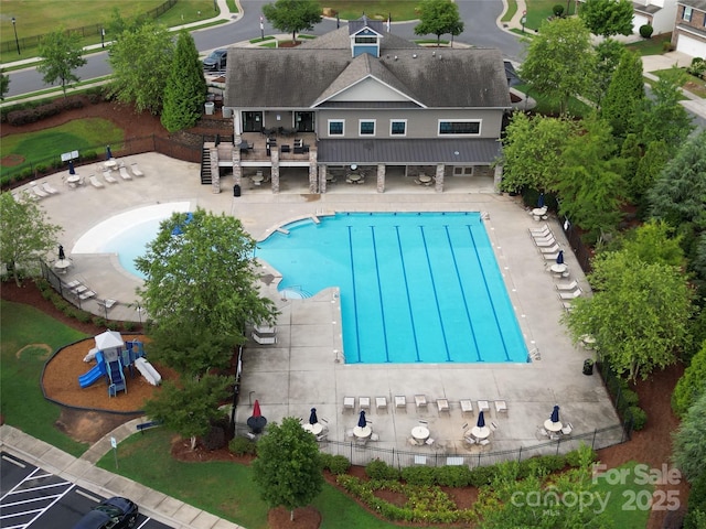 view of swimming pool with a playground and a patio area