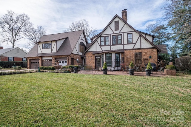 view of front of house with a garage, a patio area, and a front lawn