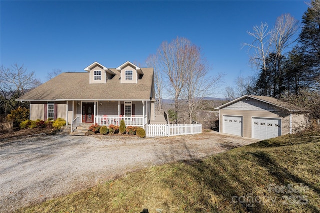 cape cod-style house with driveway, a garage, covered porch, fence, and an outdoor structure