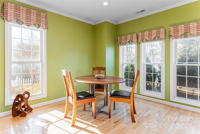 dining area with ornamental molding, visible vents, plenty of natural light, and light wood-style flooring