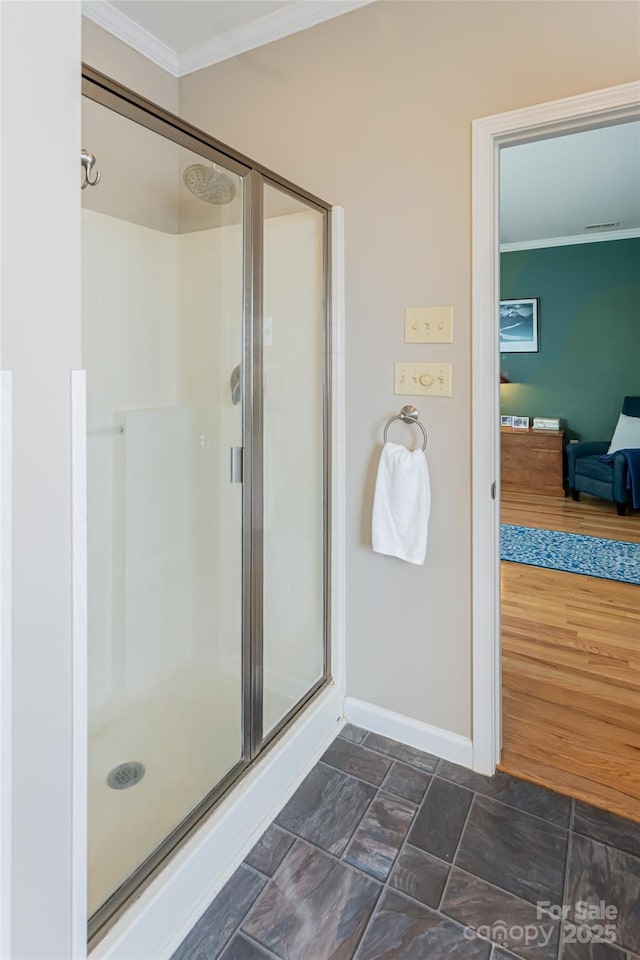 full bath with crown molding, a shower stall, and baseboards