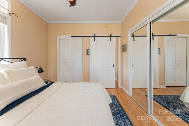 bedroom with ornamental molding and a barn door