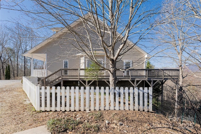 back of house featuring a fenced front yard and a wooden deck