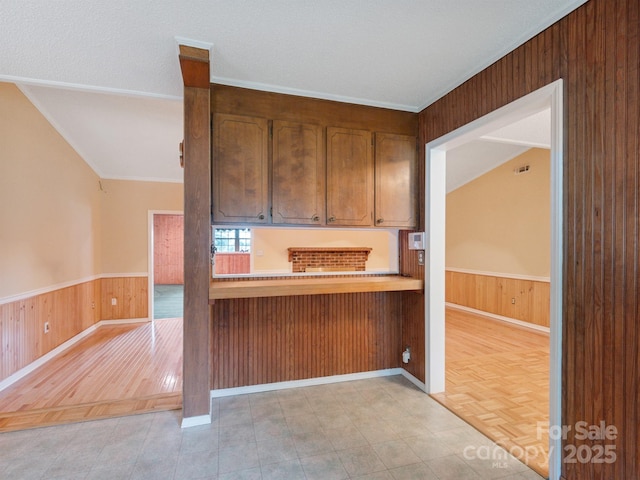 kitchen featuring wood walls, wainscoting, and light wood-style floors