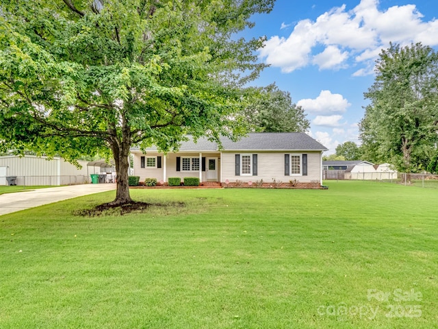 view of front facade featuring a front yard, fence, and driveway