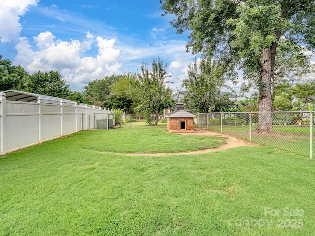 view of yard featuring an outdoor brick fireplace and a fenced backyard