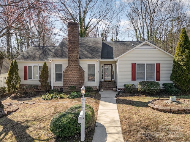 view of front of home with crawl space, roof with shingles, and a chimney