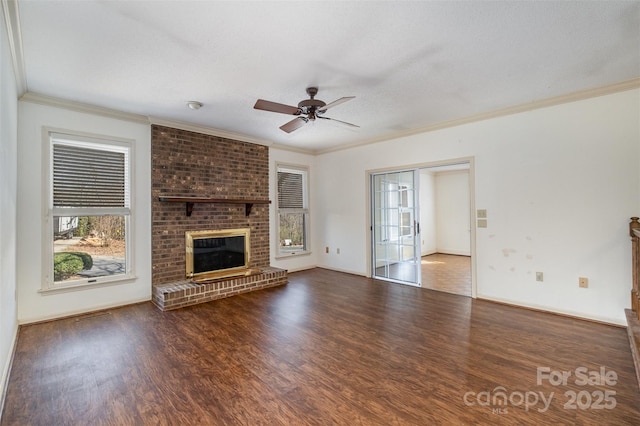 unfurnished living room with dark wood-type flooring, a textured ceiling, ceiling fan, ornamental molding, and a brick fireplace