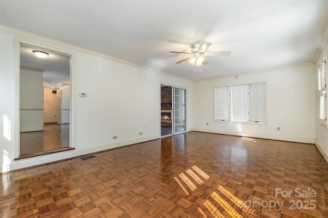 unfurnished room with ceiling fan, crown molding, and dark parquet floors