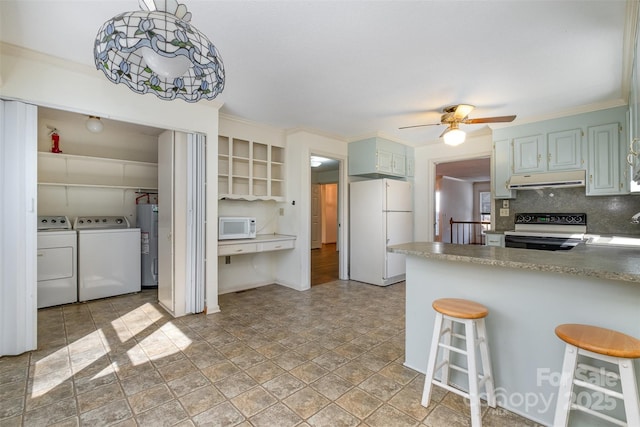 kitchen with white appliances, decorative light fixtures, water heater, kitchen peninsula, and a breakfast bar area