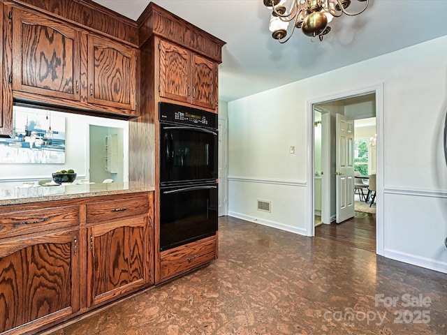 3600 Carmel Rd, Charlotte, NC 28226 - kitchen with a chandelier, dark floors, baseboards, and light stone countertops