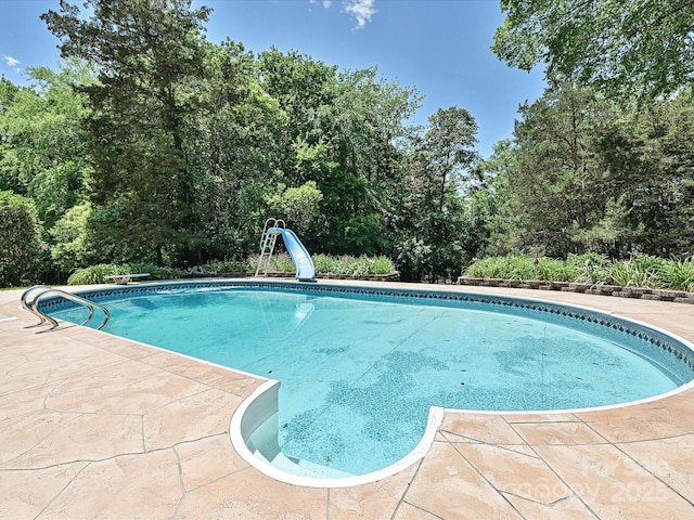 3600 Carmel Rd, Charlotte, NC 28226 - swimming pool featuring a water slide, a patio, and view of scattered trees