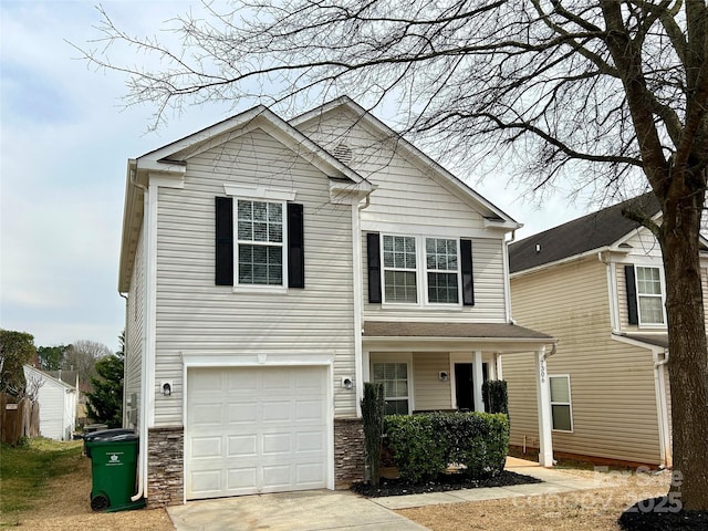 view of front of property featuring stone siding, driveway, and an attached garage