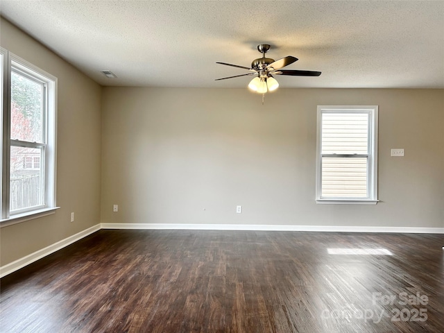 spare room with visible vents, baseboards, dark wood-style floors, and a ceiling fan