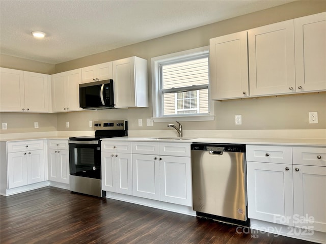 kitchen featuring white cabinets, stainless steel appliances, light countertops, and a sink