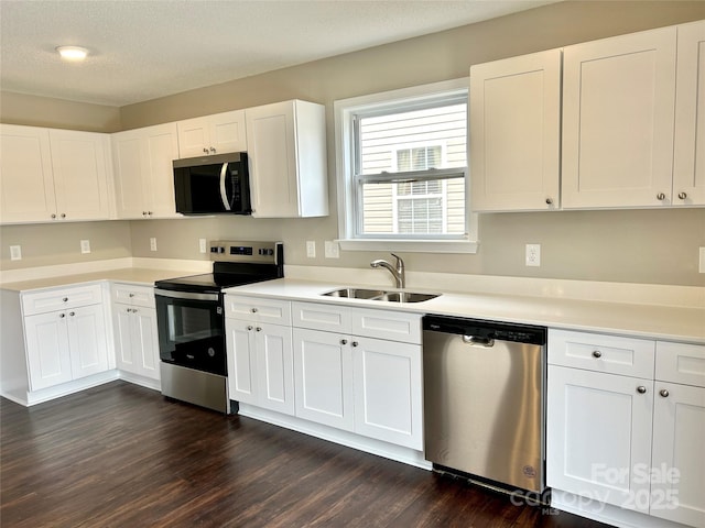 kitchen with a sink, dark wood finished floors, white cabinetry, and stainless steel appliances