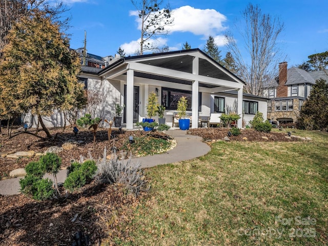 back of property featuring a lawn and a porch