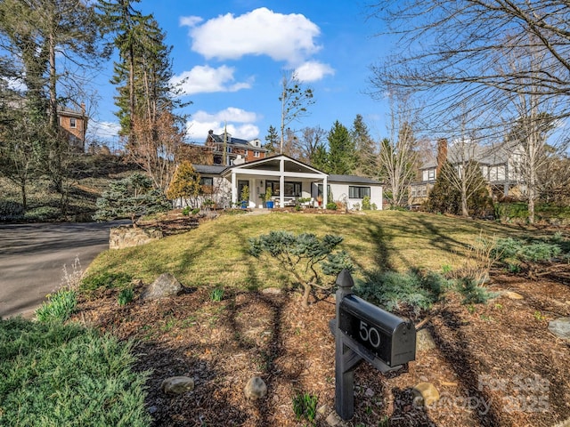 view of front of house featuring covered porch and a front yard