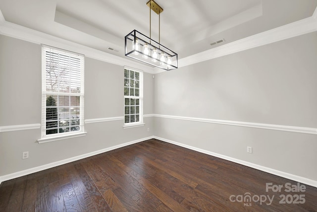 unfurnished dining area featuring visible vents, a raised ceiling, baseboards, and hardwood / wood-style flooring