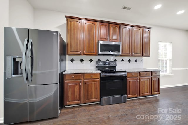 kitchen with visible vents, appliances with stainless steel finishes, dark wood-style floors, and decorative backsplash