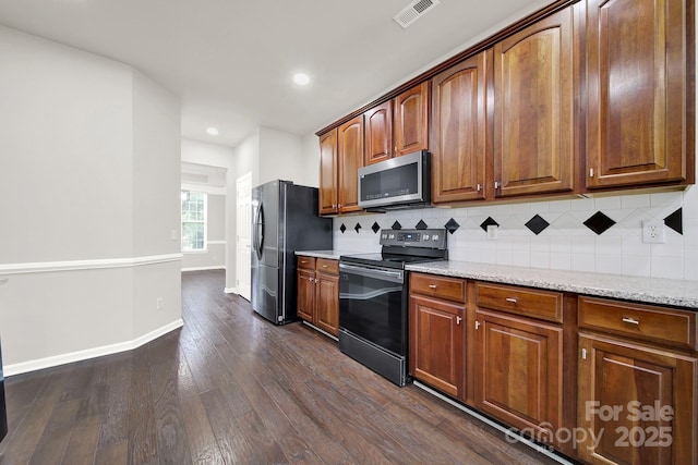 kitchen featuring visible vents, light stone counters, tasteful backsplash, stainless steel appliances, and dark wood-style flooring