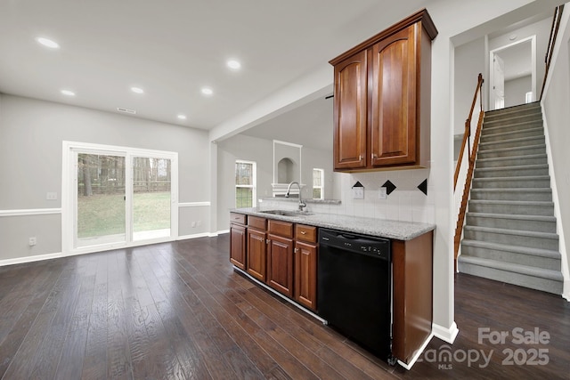 kitchen with light stone countertops, dark wood finished floors, a sink, black dishwasher, and tasteful backsplash