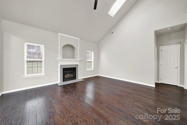 unfurnished living room with a tile fireplace, high vaulted ceiling, baseboards, and wood-type flooring