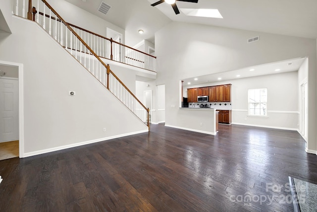 unfurnished living room featuring visible vents, dark wood-style floors, a ceiling fan, and stairway