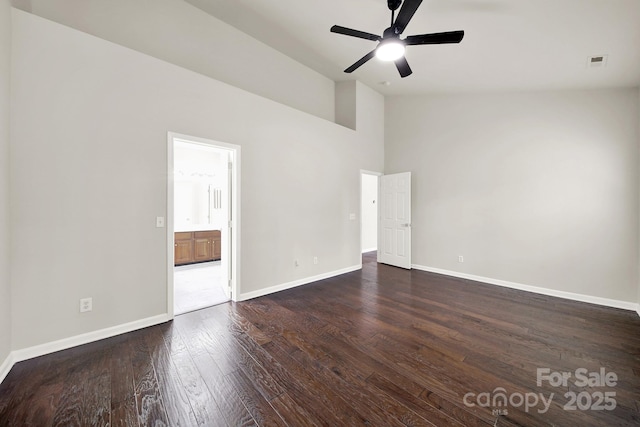 spare room with dark wood finished floors, baseboards, visible vents, and ceiling fan