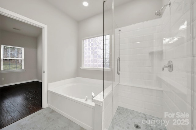 bathroom with a garden tub, plenty of natural light, visible vents, and a stall shower