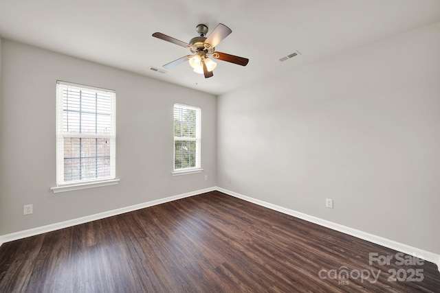 unfurnished room with visible vents, ceiling fan, baseboards, and dark wood-style flooring