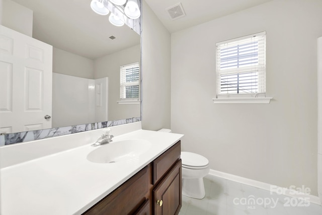 bathroom with vanity, toilet, visible vents, and a wealth of natural light