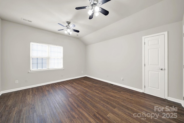 unfurnished room featuring visible vents, lofted ceiling, a ceiling fan, and dark wood-style flooring