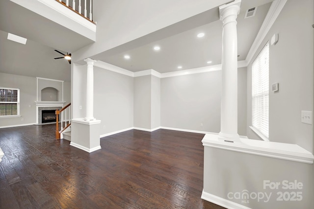 living area featuring visible vents, ornamental molding, ornate columns, and wood finished floors