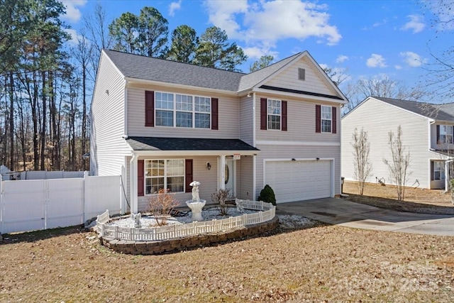 traditional-style house featuring fence, driveway, and an attached garage