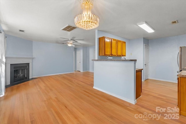 kitchen with light wood-style flooring, visible vents, and brown cabinets