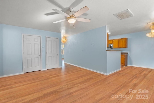 unfurnished living room with ceiling fan, baseboards, light wood finished floors, and visible vents