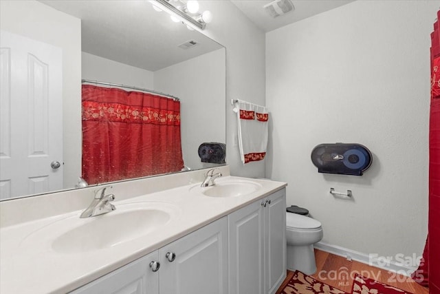 bathroom with toilet, a sink, baseboards, and visible vents