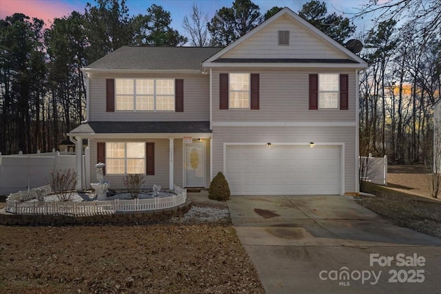 traditional-style house with covered porch, fence, concrete driveway, and an attached garage