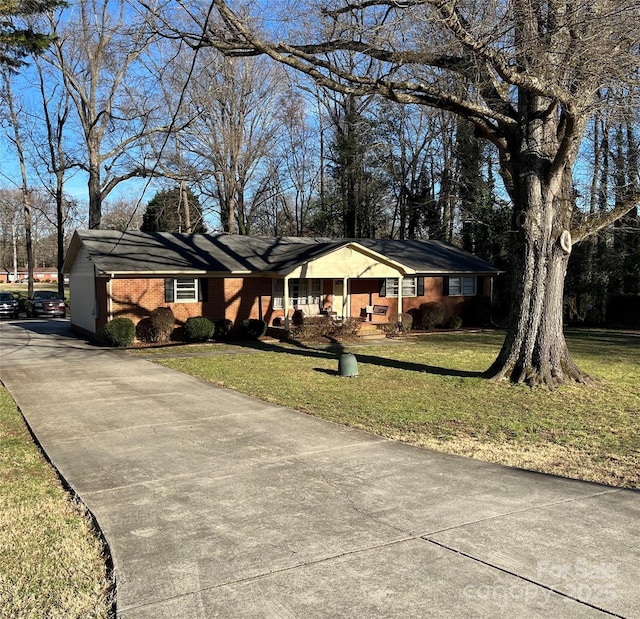 single story home featuring covered porch and a front lawn