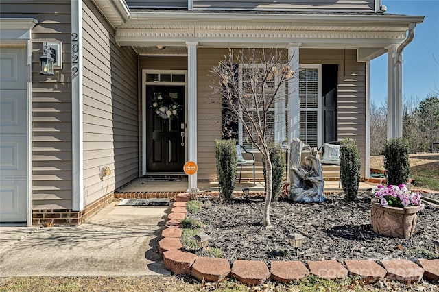 entrance to property with a porch and an attached garage