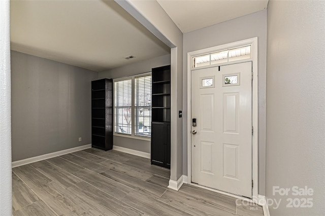 entrance foyer featuring baseboards and wood finished floors