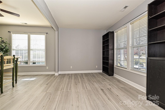 empty room featuring ceiling fan, light wood-type flooring, visible vents, and baseboards