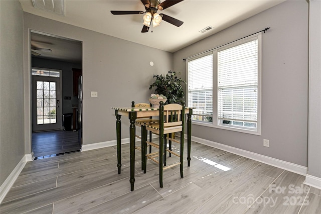 dining room with baseboards, visible vents, and light wood-style floors